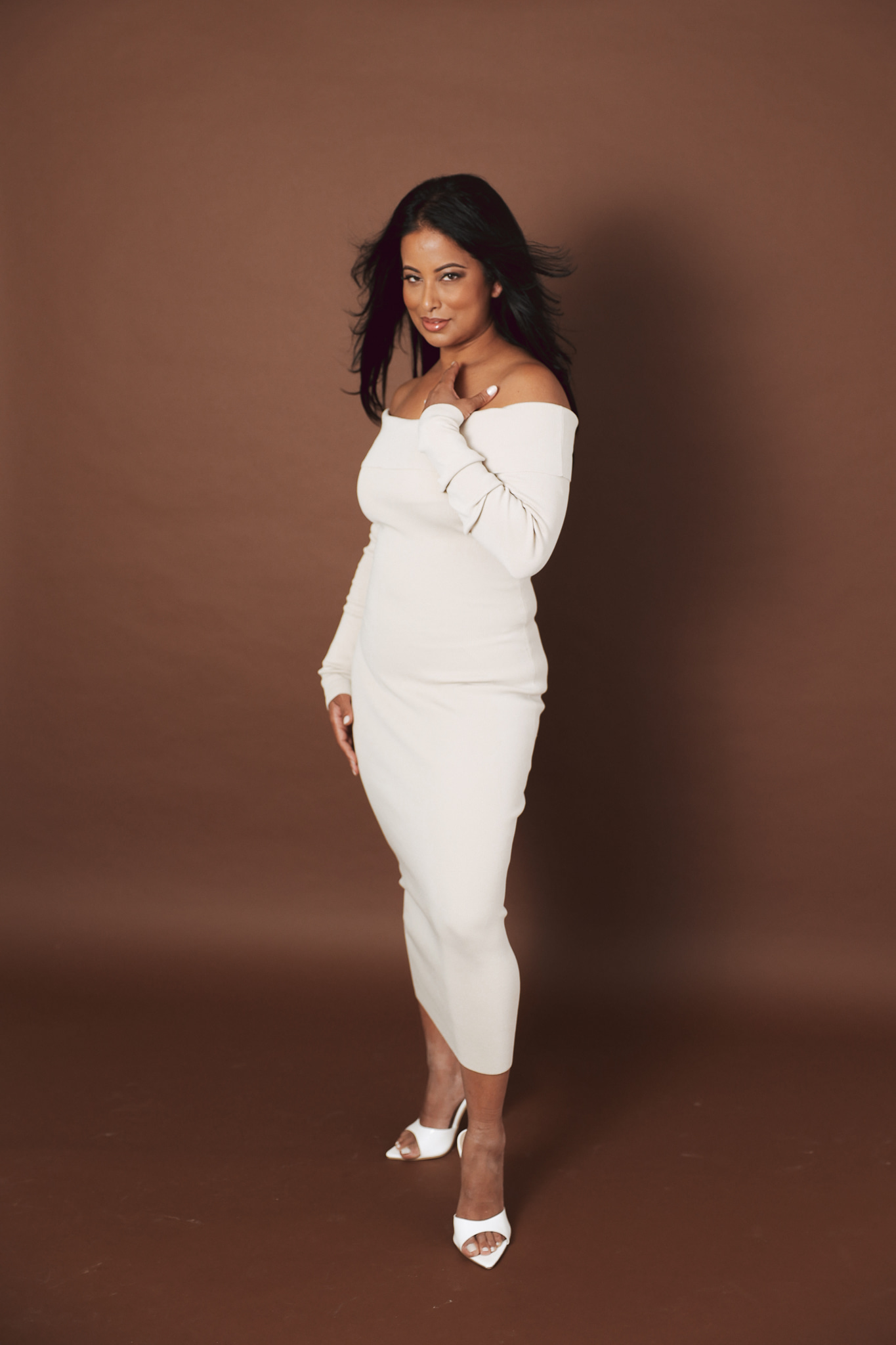 Roshani Patel in a cream dress and white heels
